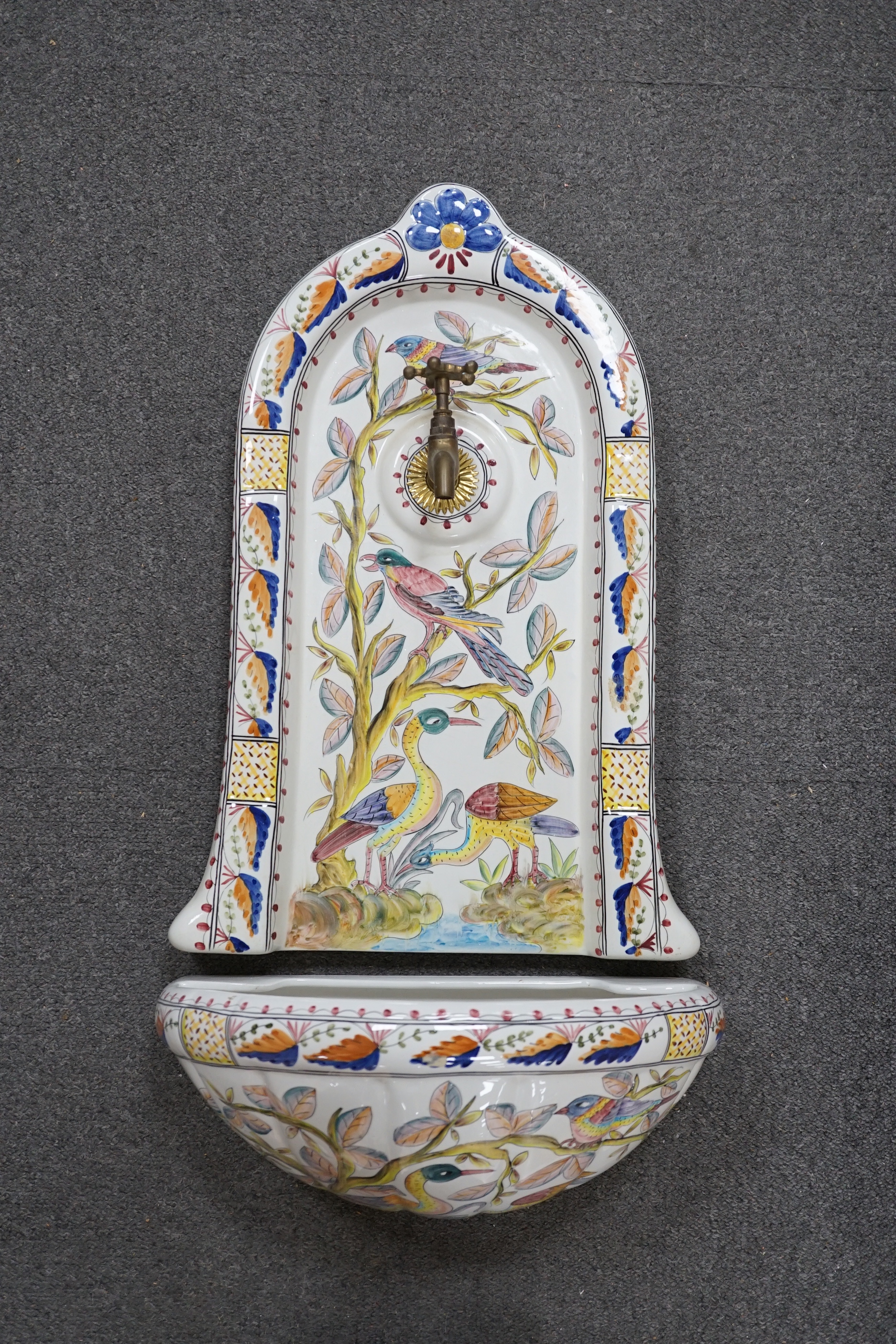 A Portuguese pottery font and basin, hand painted with birds and flowers, 66cm high